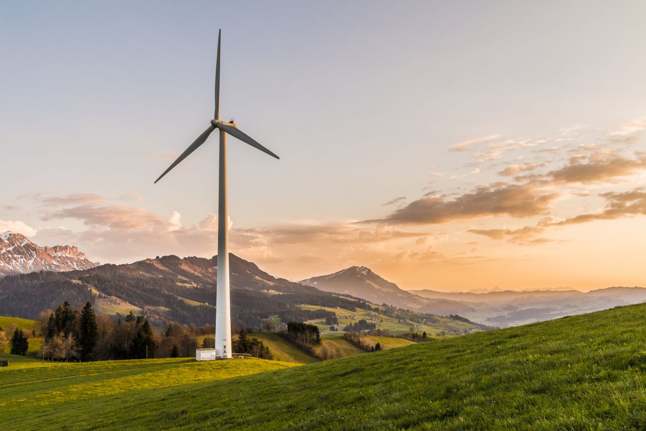 Wind turbines on a ridge under cloudy sky